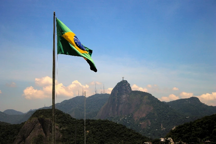 a flag on a pole in front of a mountain